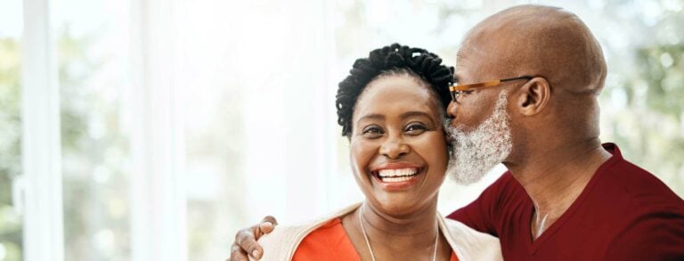 An older couple smiling at each other.