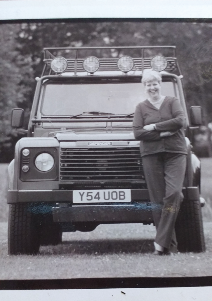 In this archival photo, Anne Youngson leans against one of the Defender brand vehicles she helped create.